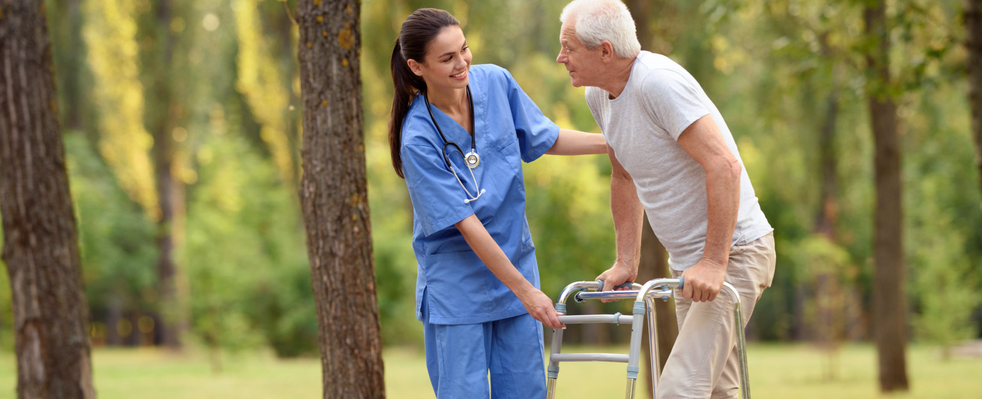 caregiver assisting senior man in walking
